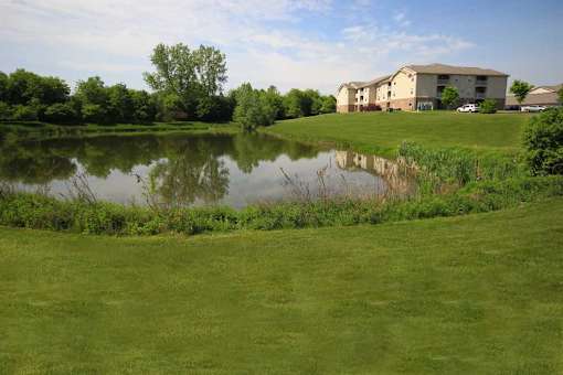 a small pond in front of apartment buildings at Canterbury Apartments in Kalamazoo, MI