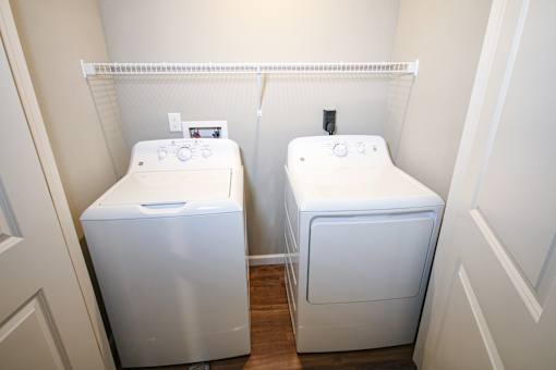 Two white washing machines in a small room.