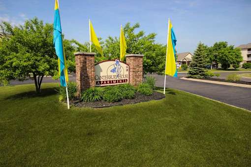 a sign in the grass for Canterbury Apartments in Kalamazoo, MI
