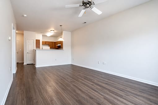 A room with a ceiling fan and wooden flooring.