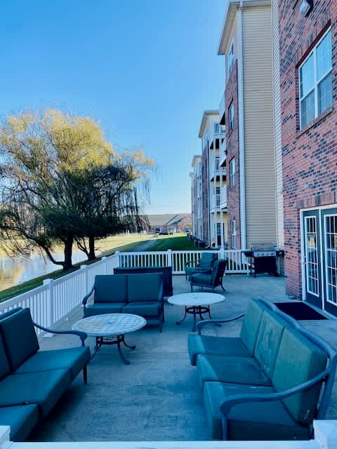 A patio with a table and chairs overlooking a body of water.