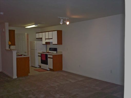 A kitchen with white appliances and wooden cabinets.