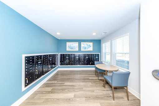 A room with a blue wall and a white ceiling with a table and chairs.