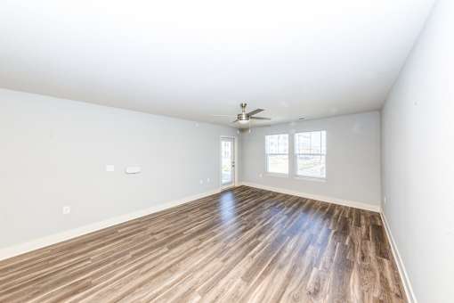 A room with a wooden floor and a ceiling fan.