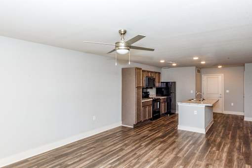 A room with a ceiling fan and wooden flooring.
