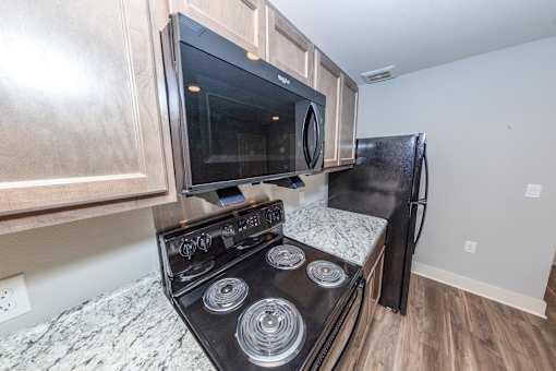 A black stove top oven with a microwave above it.