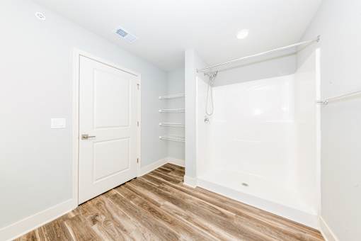 A white door is on the left and a white bathtub is on the right.
