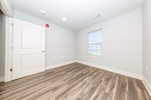 A room with a wooden floor and a window.
