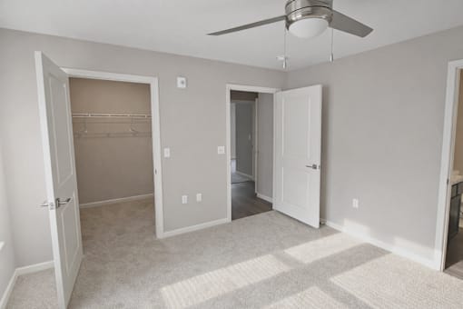 A room with a ceiling fan and a carpeted floor.