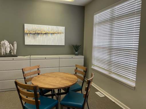 A dining room with a round wooden table and chairs.