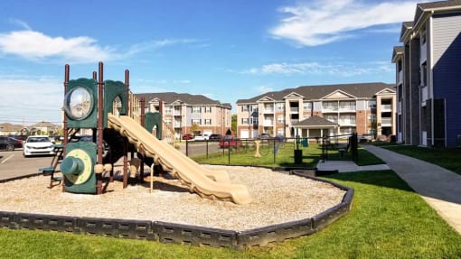 Playground with a slide and clock in front of Mosaic Apartments in Avon, Indiana