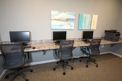 Three chairs are placed in front of three computers.