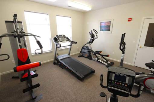 Fitness center with cardio equipment and a weight machine at Canterbury Apartments in Kalamazoo, Mi