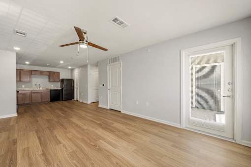A room with a ceiling fan and wooden flooring.
