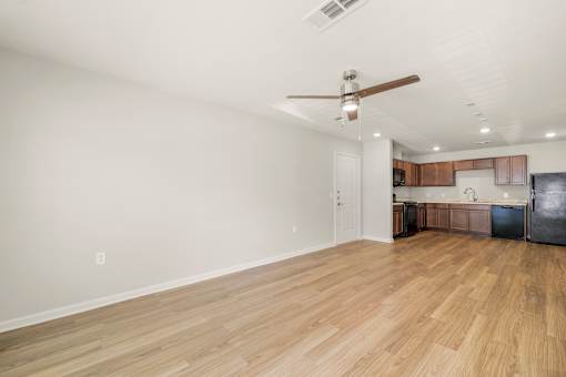A room with a ceiling fan and wooden flooring.