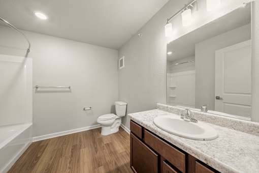 A white bathroom with a toilet, sink, and bathtub.