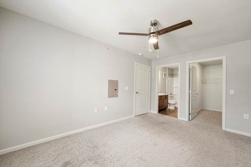 A room with a ceiling fan and a carpeted floor.