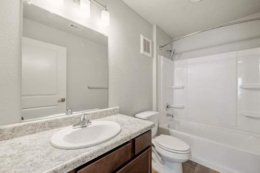 A white bathroom with a sink, toilet, and bathtub.