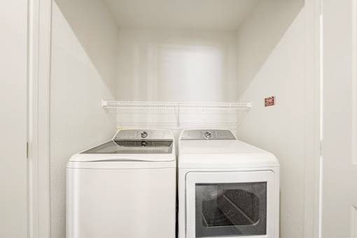 A white washing machine and dryer in a small laundry room.