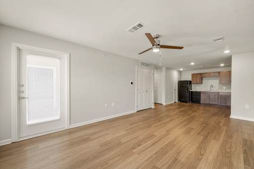 A room with a ceiling fan and wooden flooring.