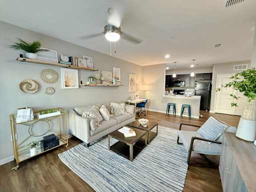 A living room with a white couch, a coffee table, and a ceiling fan.