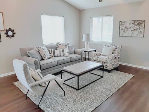 Clubhouse living room with a couch and chairs and a table at Frankfort Place apartments