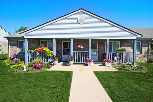 the front of Frankfort Place apartments clubhouse with flowers on the porch