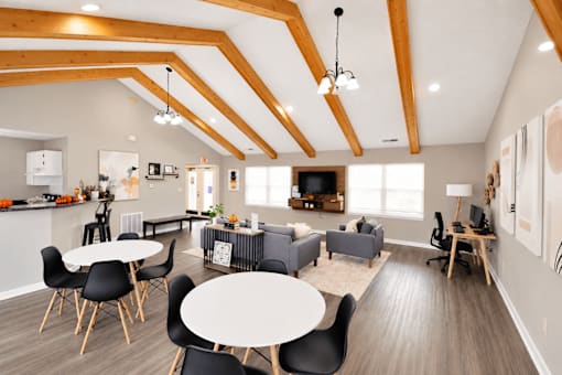 A modern open plan living and dining area with a kitchen in the background.