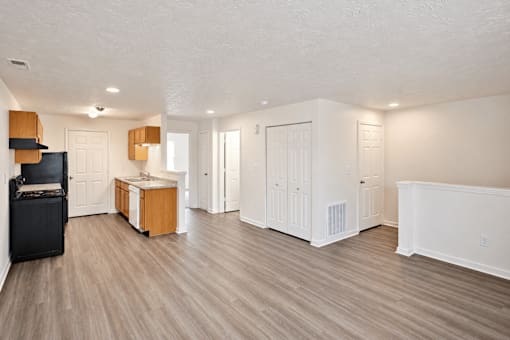 A room with white walls and wooden floors has a flat screen TV and a wooden cabinet.