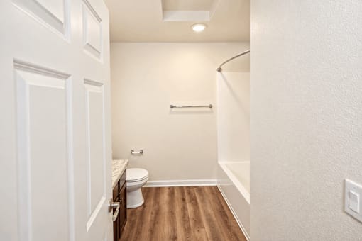 A white bathroom with a toilet and a shower.