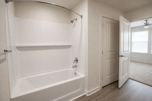 A white bathroom with a tub and a shower.