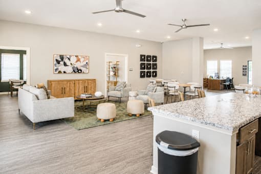 A modern living room with a kitchen area in the background.