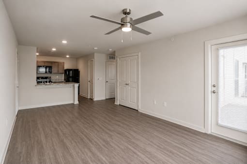 A spacious room with a ceiling fan and light fixture.