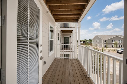 A white deck with a wooden floor and a white railing.