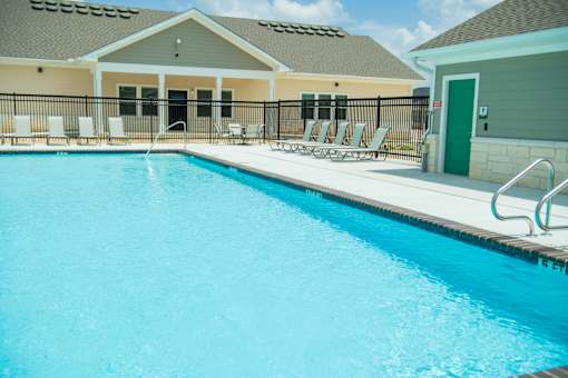 A swimming pool with a metal railing and a green door.