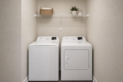 Two white washing machines in a laundry room.