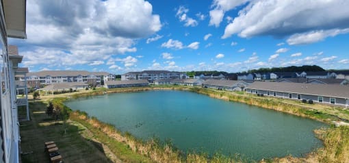 a large pond with southern meadows apartment buildings around it