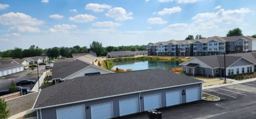 an aerial view of a building with a pond in the middle