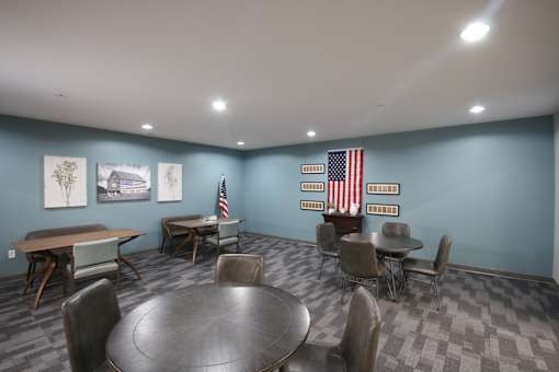 A room with a table and chairs and flags on the wall.