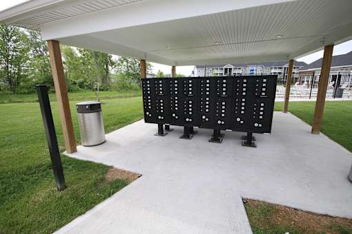 A black scoreboard with white numbers is in the middle of a grassy area.