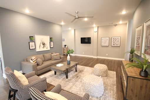 A living room with a grey couch, a coffee table, and a television.