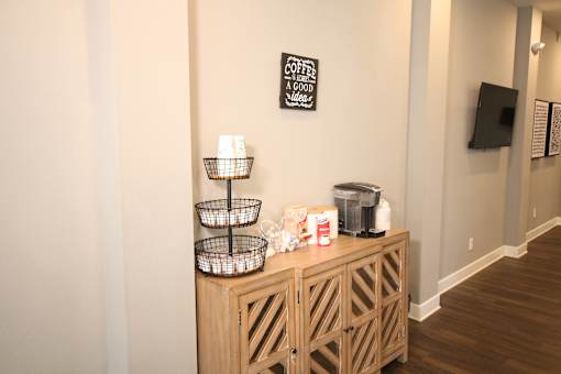 A wooden cabinet with a coffee sign on the wall above it.