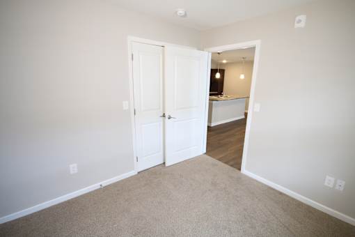 A room with a white door and carpeted floor.