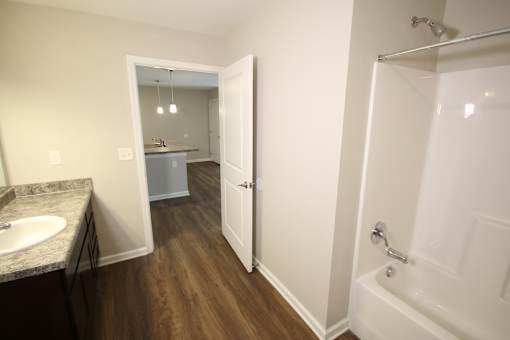 A bathroom with a white tub and a sink.