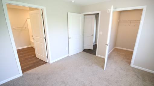 A room with three open doors and a carpeted floor.