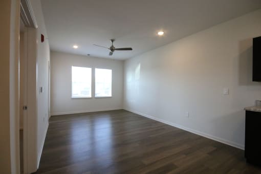 a living room with wood floors and a ceiling fan