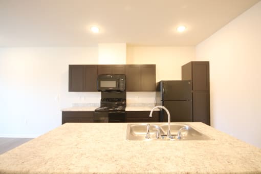 a kitchen with black appliances and a granite counter top