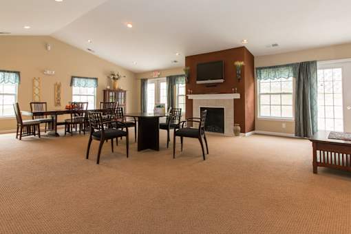 A large room with a fireplace and a TV on the wall.