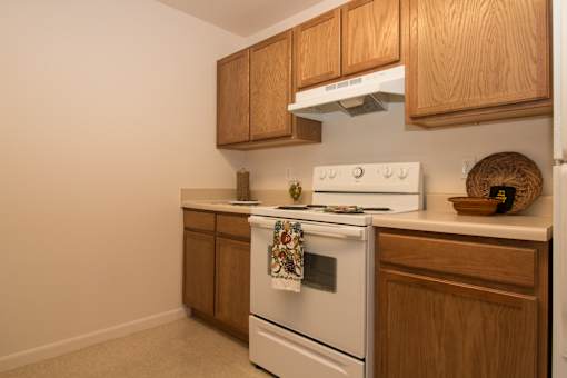 A white stove top oven with a towel on it.