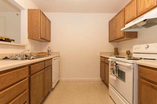 A kitchen with wooden cabinets and white appliances.